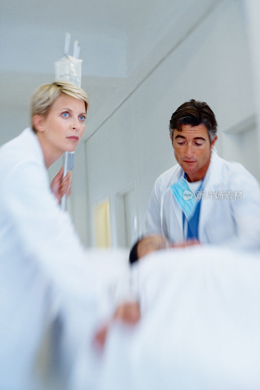 两名医生带着一个躺在担架上的病人匆忙赶来