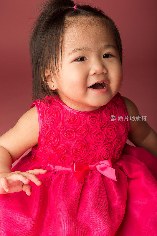 微笑的亚洲幼童在粉红色的背景