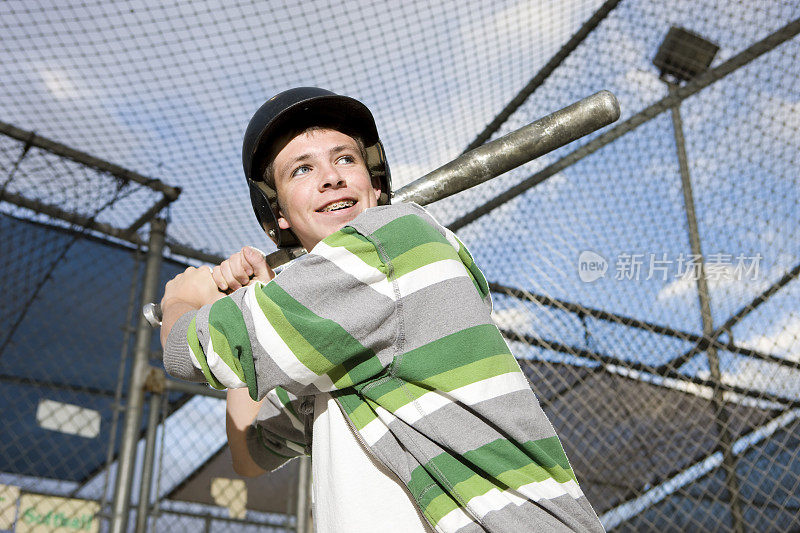 男孩挥动棒球在击球笼