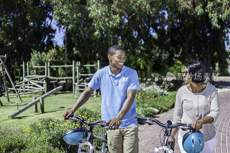 一对非洲夫妇在骑了几个小时的自行车后骑着自行车散步
