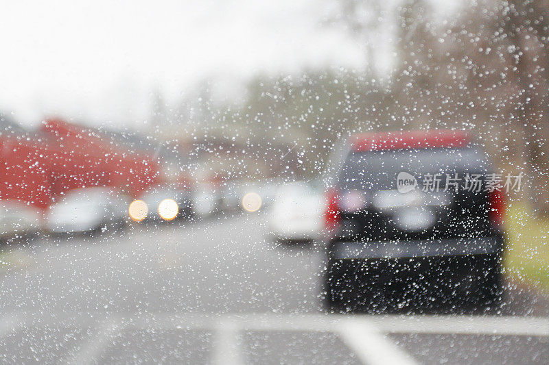 在抽象的挡风玻璃雨中停放的汽车