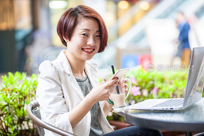 一名年轻女子在咖啡厅使用笔记本电脑。