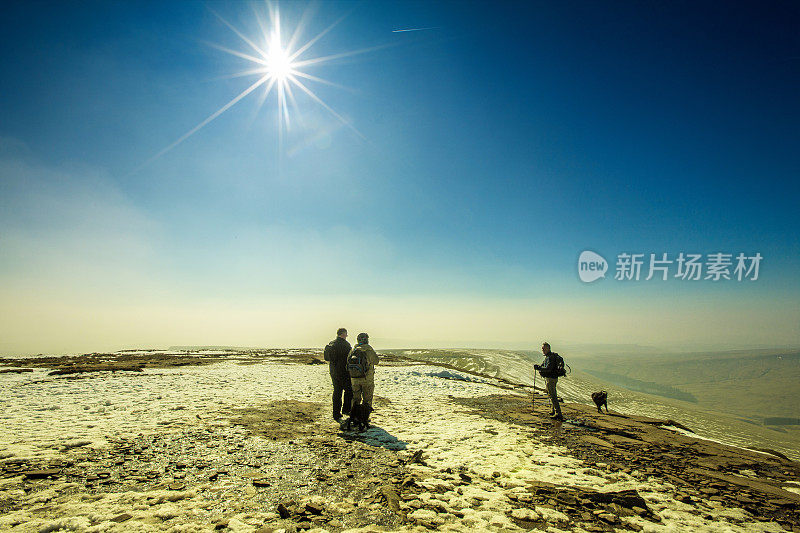 三个成熟的步行者在白雪覆盖的山上