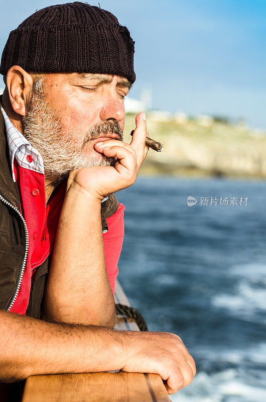 意大利老渔夫抽着雪茄放松
