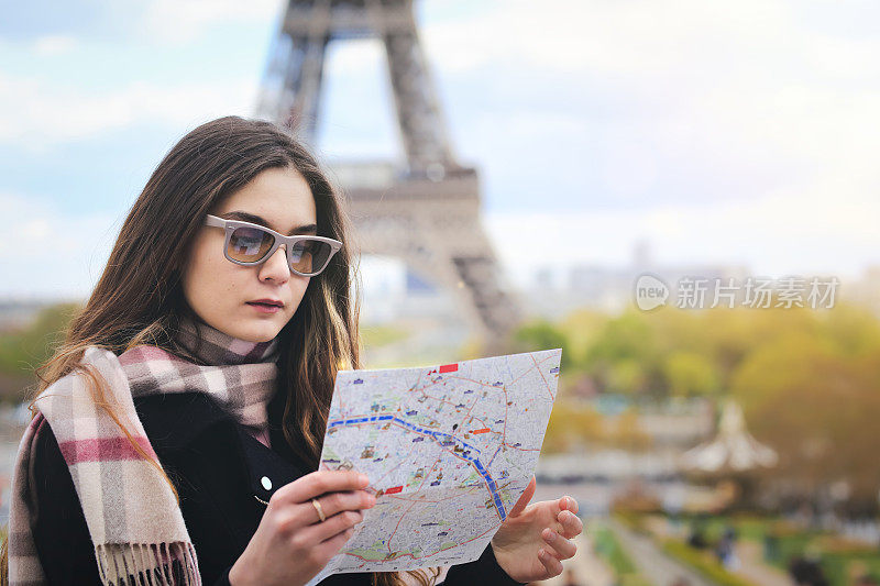 女游客拿着巴黎埃菲尔铁塔的地图