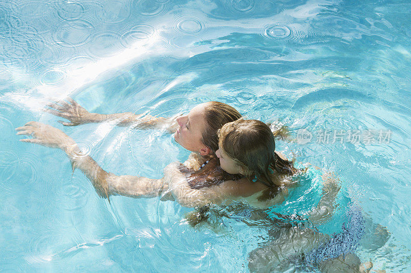 母亲和女儿在游泳池里
