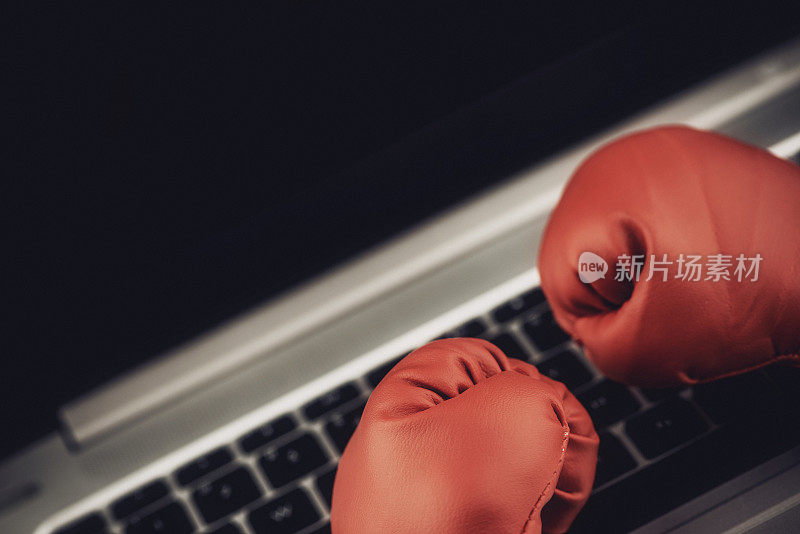 带笔记本电脑的拳击手套:网络欺凌的概念形象