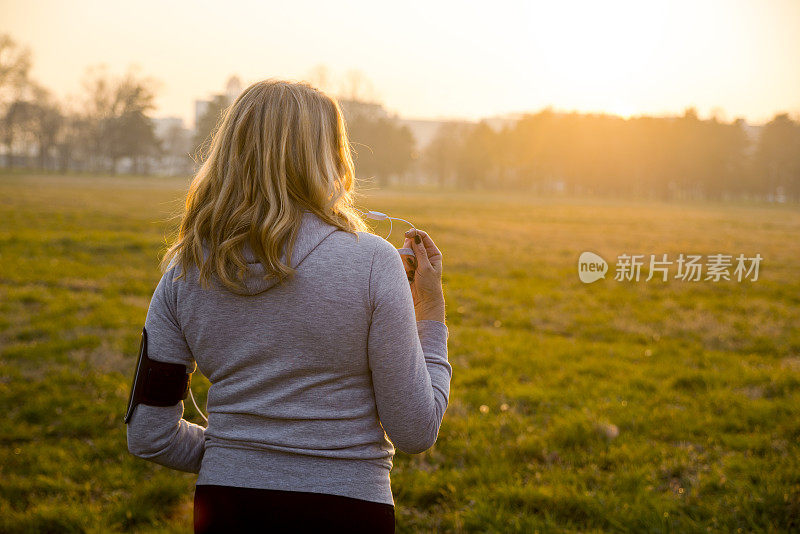 成熟的女人在秋天的公园做晨跑