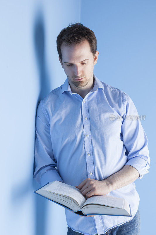 穿蓝白衣服的人在读一本书