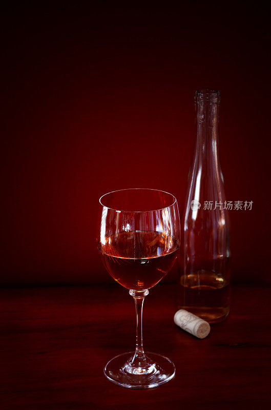 红色背景上的酒杯和酒瓶