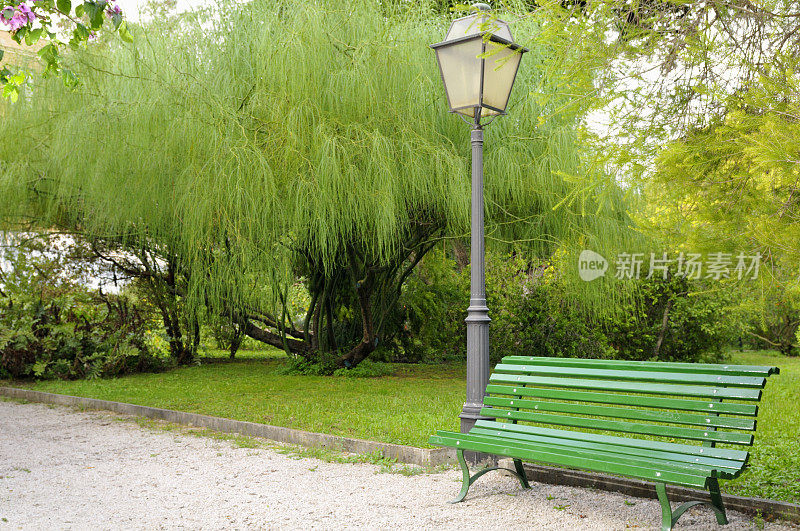 绿色花园的长凳和灯柱