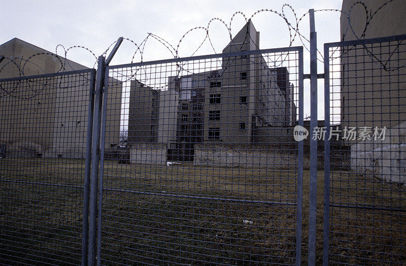 背景是铁丝网和建筑群