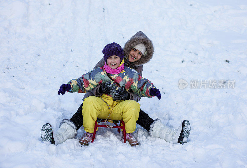 母亲和女儿喜欢坐雪橇