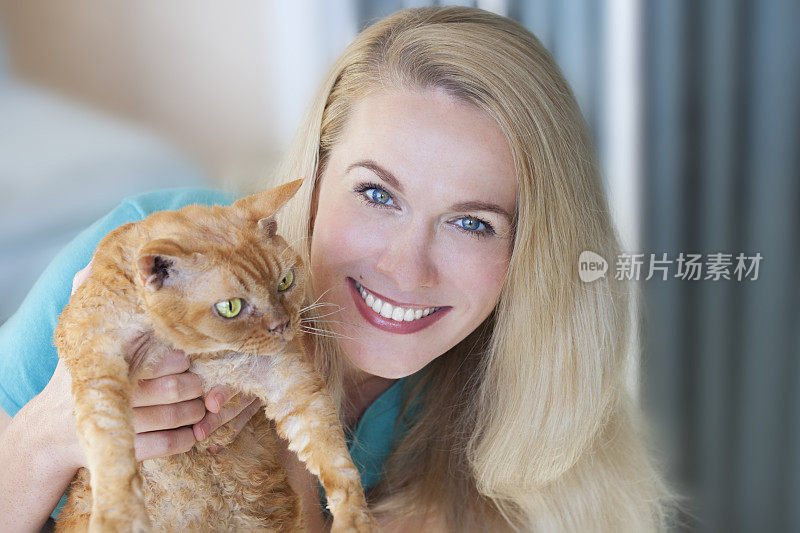 漂亮女人抱着一只姜黄色的猫