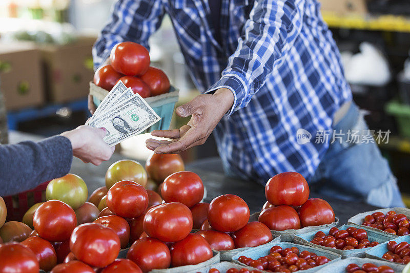 顾客在农产品摊上购买西红柿