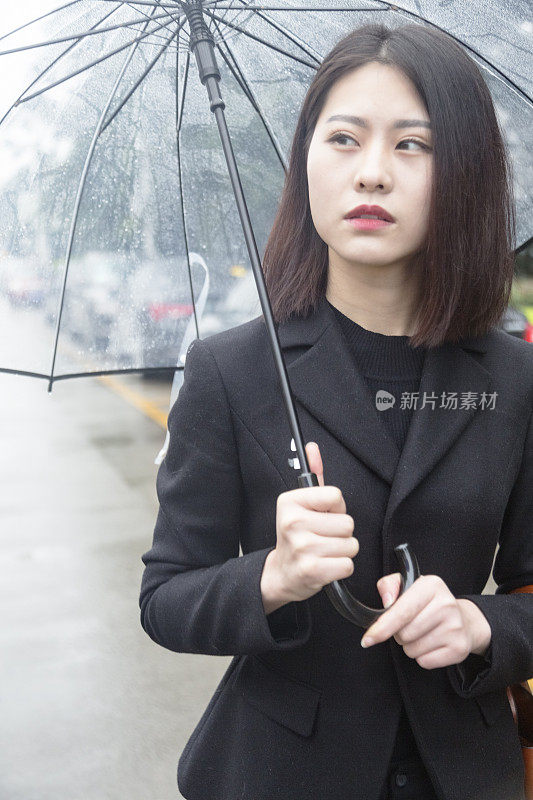 一个带着雨伞走在街上的女商人的肖像