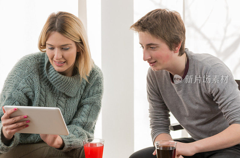 弟弟和妹妹在客厅里使用数码平板电脑。