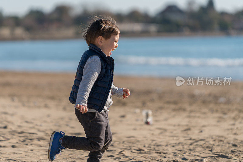 小男孩在海滩上跑步