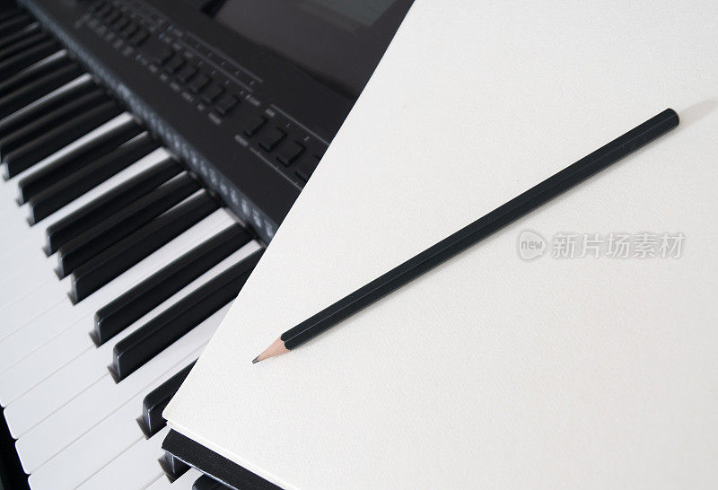 钢琴键盘，笔和表。作曲的概念。