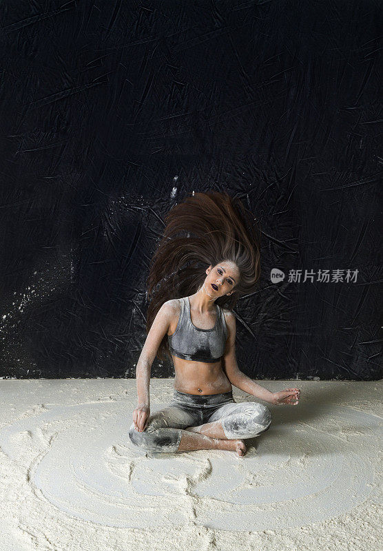 在土耳其伊斯坦布尔的工作室里，一名年轻女子在灰尘和粉末中跳舞