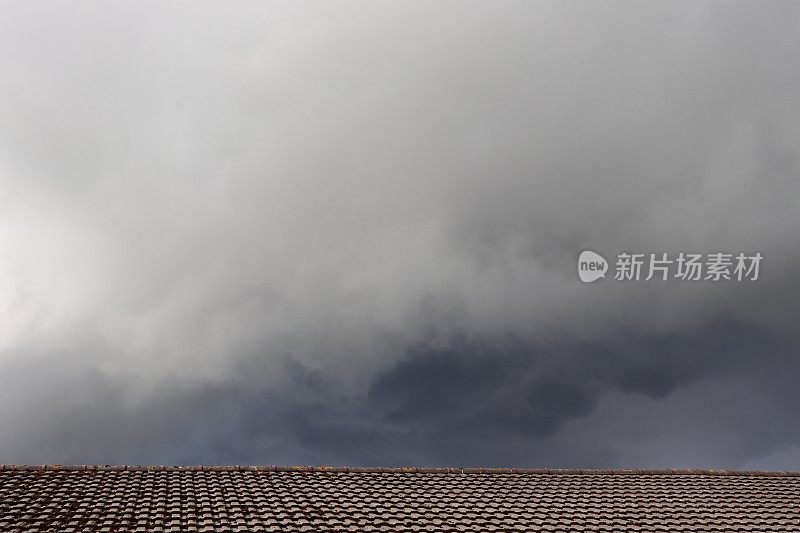 乌云密布的天空，乌云笼罩着瓦房的屋顶