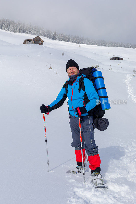 冬日里，在白雪覆盖的山谷中徒步旅行的人