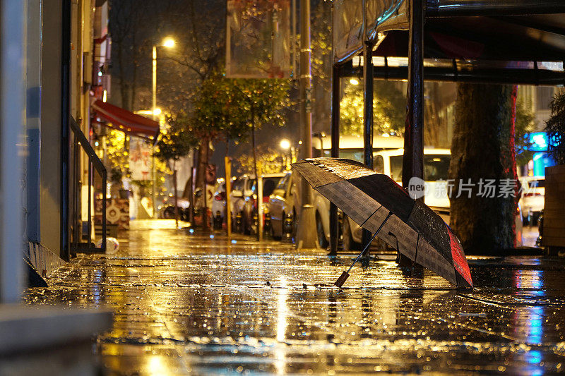 雨天。雨伞在街上。路灯