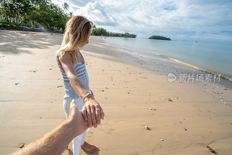 跟我来概念女人领先的男朋友在泰国田园海滩。人们旅行豪华度假目的地的概念