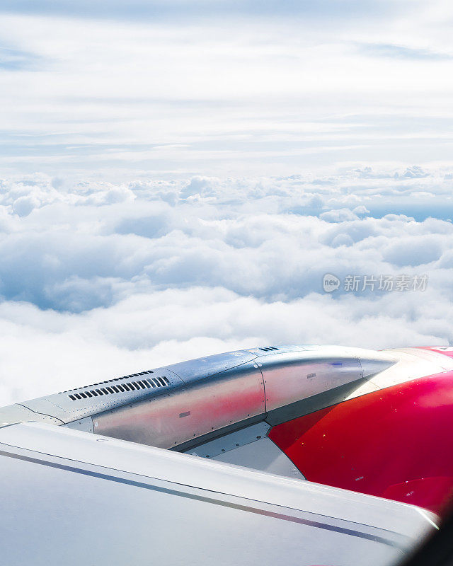 飞机的机翼在天空中飞过云层