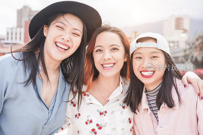 亚洲女性最好的朋友有乐趣的户外-快乐的时尚女孩一起笑-千禧一代，连接，友谊和聚会的概念-关注脸