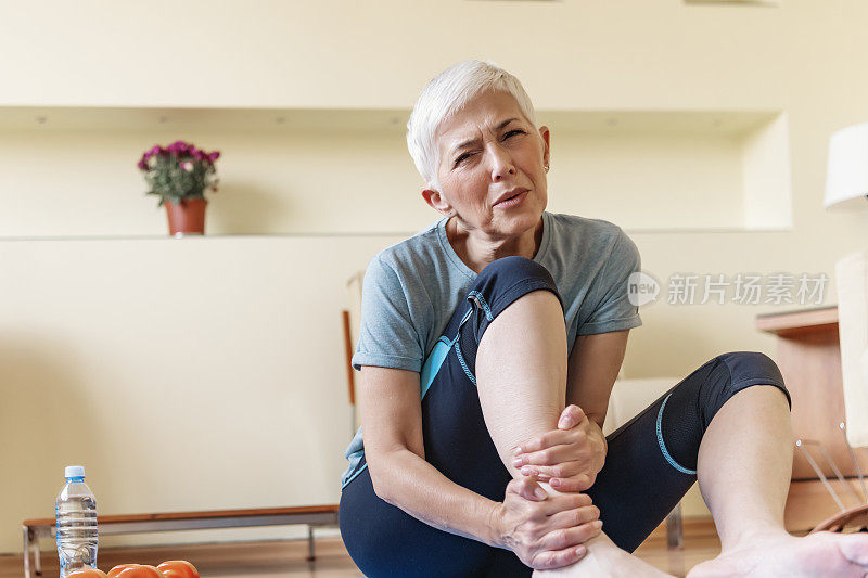 不快乐的成熟女人坐在垫子上