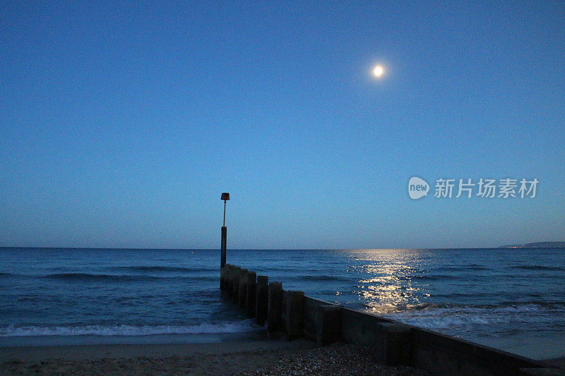 映入眼帘的是木坝上的夜空，月亮照在水面上，温柔的，波光粼粼的海浪拍打着沙滩