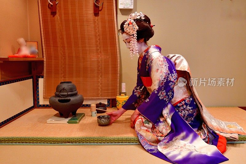 日本京都茶馆，一名身穿舞子服装的日本妇女在练习茶道