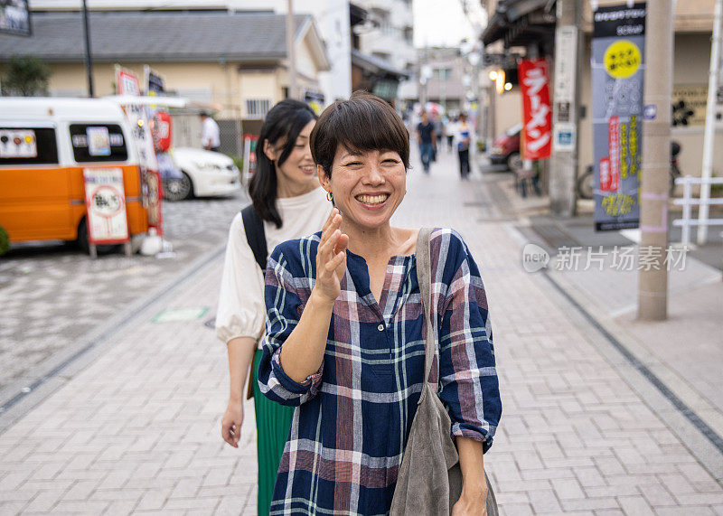 女性朋友走在购物街上