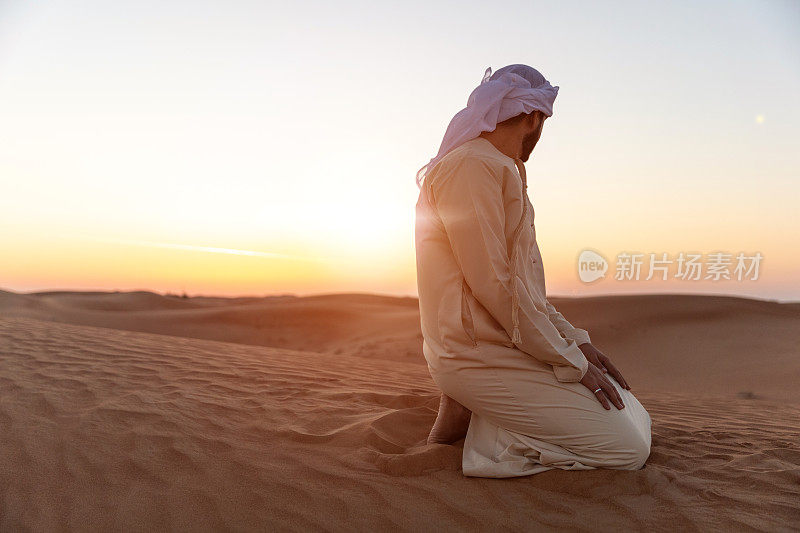 日落时分，沙漠中身着传统阿拉伯服饰的中东男子