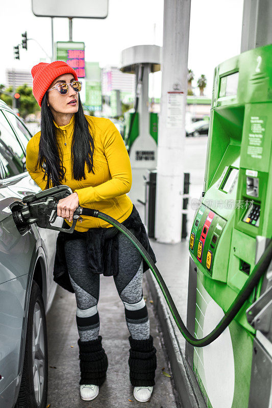 一位现代妇女在加油站给她的车加油
