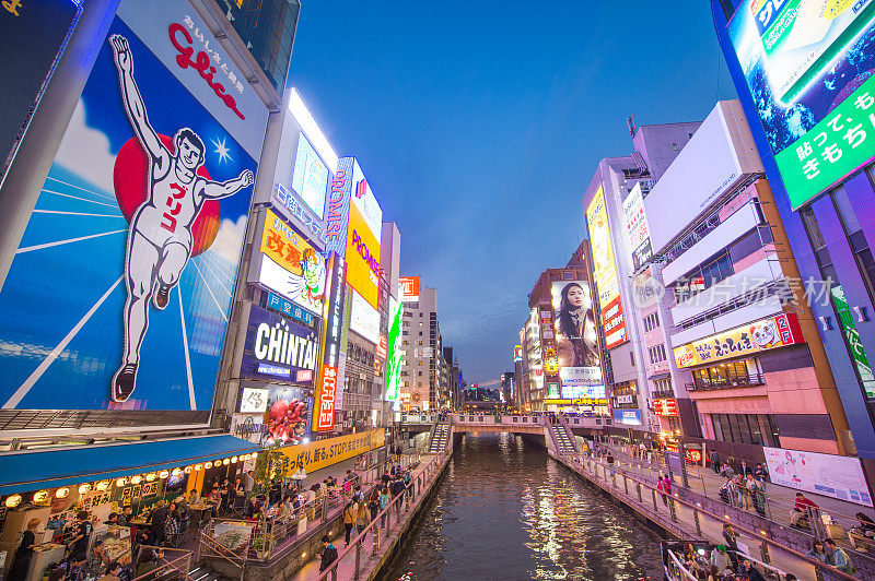 在日本大阪的道顿堀，五颜六色的广告牌照亮了大阪夜市周围的商店和零售店