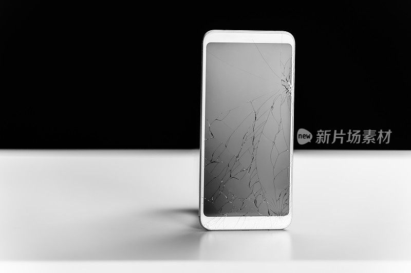 黑白背景的碎裂屏幕的智能手机