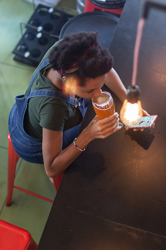 非洲妇女享受和喝啤酒在吧台
