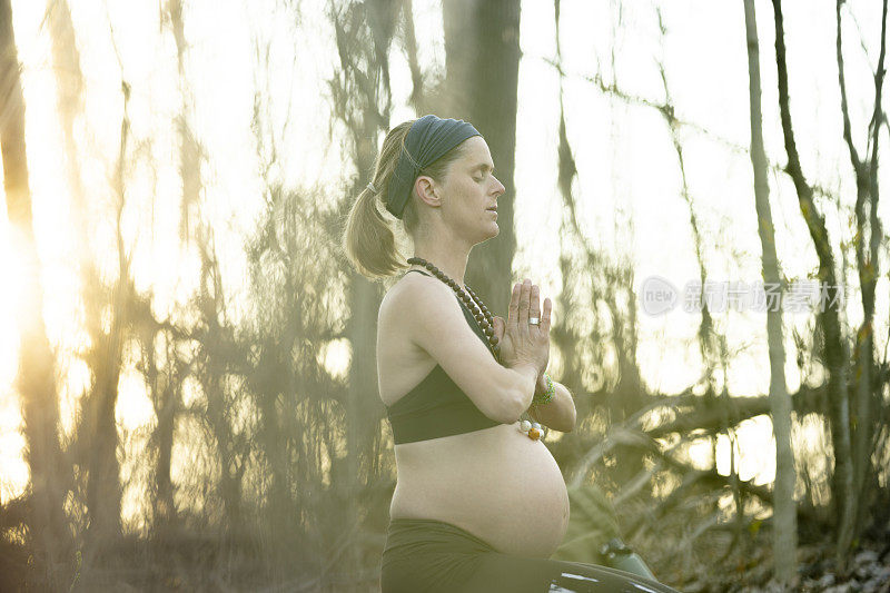 在森林里祈祷的孕妇
