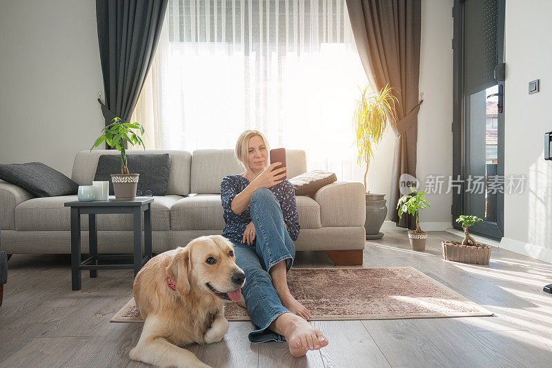 女人与她的金毛猎犬在家里玩得很开心。