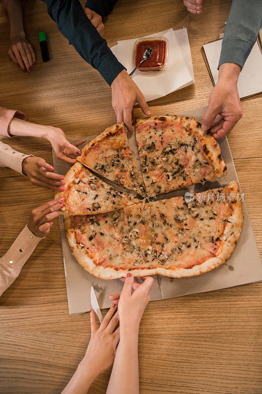 一群人在午休时间每人吃一片披萨