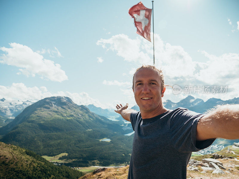 一名年轻人在山顶用瑞士国旗自拍