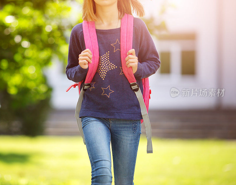 一个背着背包的女孩站在教学楼前