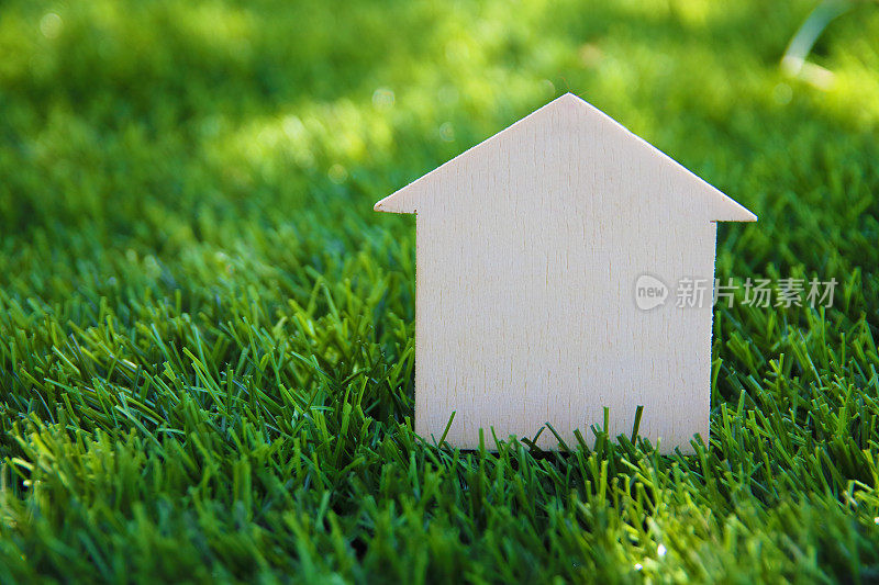 闭合的小房子模型在绿色草地上