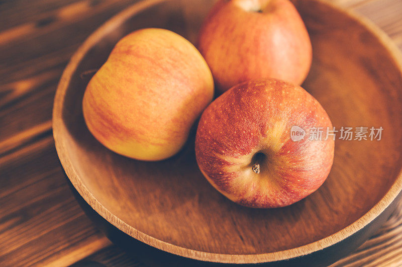 熟透的新鲜苹果放在木碗里。