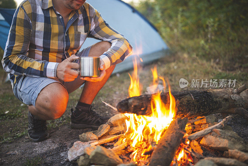 一个陌生的人在篝火旁露营