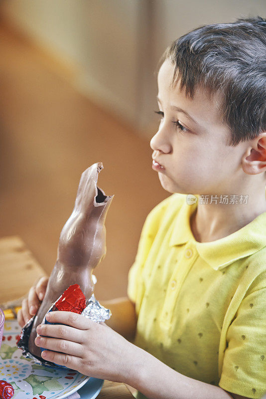 小男孩吃巧克力复活节兔子