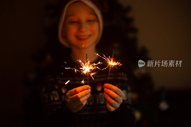 快乐微笑的白人男孩拿着烟花。