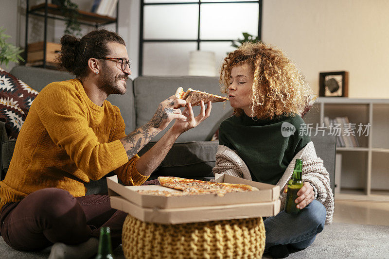 幸福的夫妇在家吃披萨。库存图片